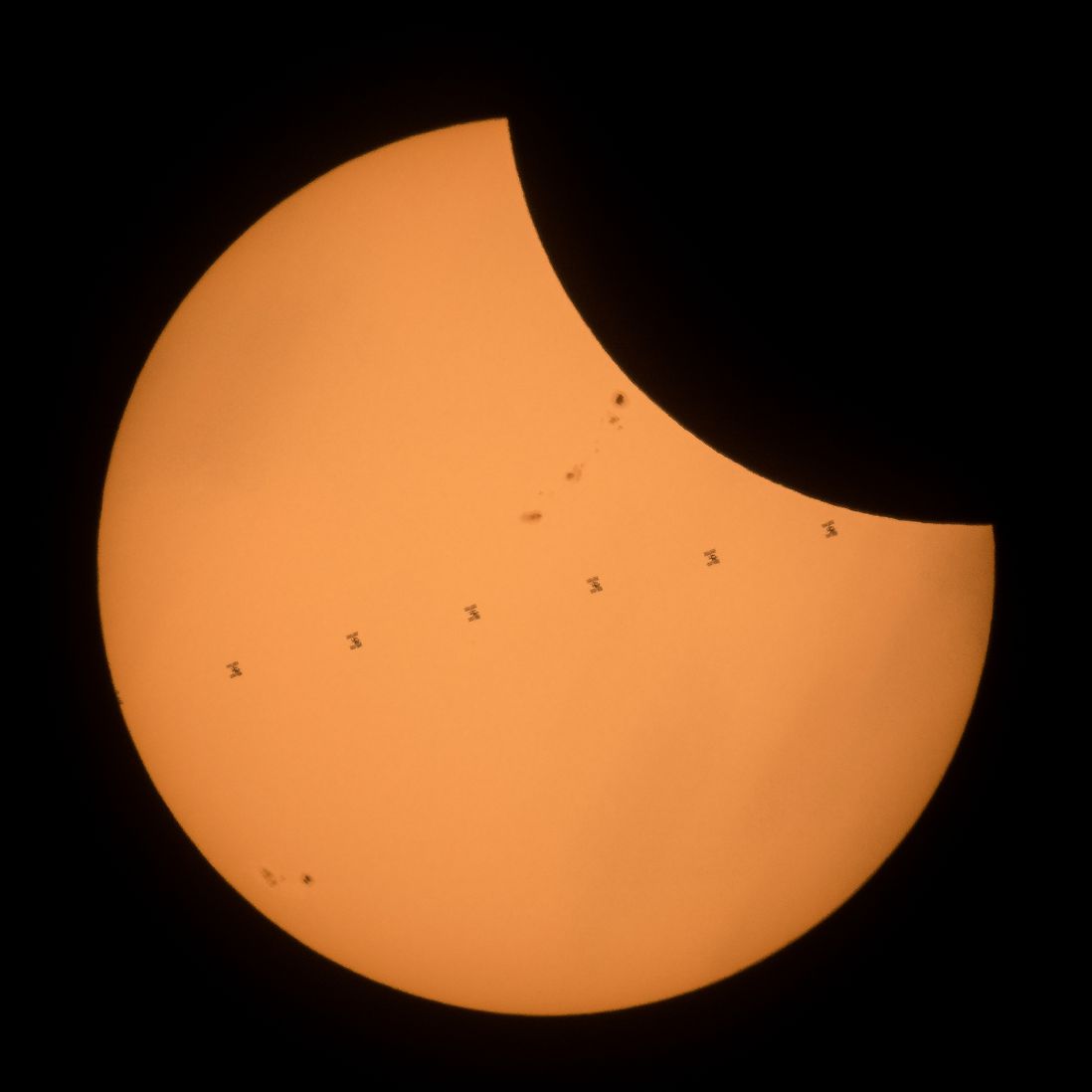 This composite image, made from seven frames, shows the International Space Station, with a crew of six onboard, as it transits the Sun at roughly five miles per second during a partial solar eclipse, Monday, Aug. 21, 2017 near Banner, Wyoming.